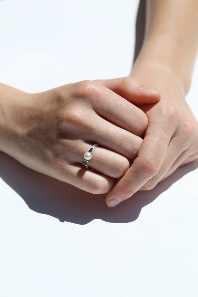 La bague LA PERLE allie découpe affûtée et asymétrique à l'élégance délicate de la perle Akoya. La perle est comme en suspens, arrimée à la matière d'un côté, et en lévitation de l'autre. Comme par magie.
En argent 925 ou argent plaqué or 3µ à 24k.

Fabriquée en Italie et en France.

Perle certifiée Akoya du Japon. Environ 5,5x6mm.&nbsp;
