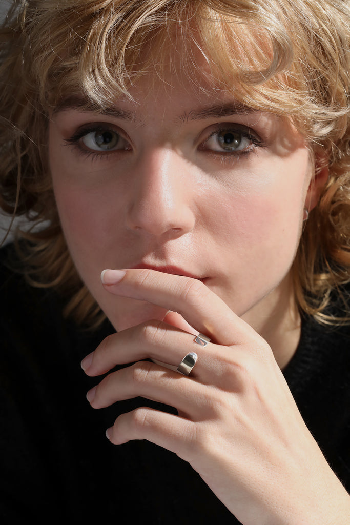 LA BEAUTÉ est disponible en tout or 18k, or jaune, blanc ou rose.

Petite soeur de L'AVENTURE, LA BEAUTÉ s'inspire elle aussi des sculptures monumentales de'Eduardo Chillida. Elle nous inspire le calme, la force intérieure. Pareilles à un stabile miniature, ses formes pleines et denses découpent le vide de manière incisive. Une harmonie imperturbable.
Largeur : 6mm // Épaisseur : 1,5mm - 2mm
Or 18k certifié 100% recyclé RJC-COC.