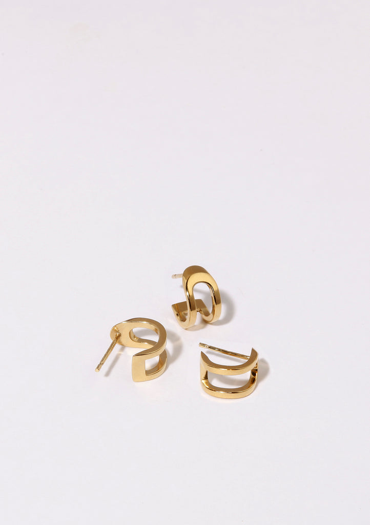 Boucles d'oreilles Maison Mouche au design épuré et architectural, en vermeil 100% recyclé et tracé, fabriquées dans des ateliers eco-responsables en Italie. Cette mini boucle L'AVENTURE enrobe discrètement l'oreille, elle est un jeu d’oppositions et de ruptures entre courbes et segments. Les biais accentuent les perspectives, la lumière avive les angles et découpe les espaces.