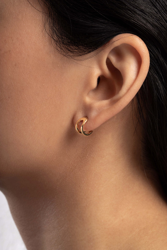 Boucles d'oreilles Maison Mouche au design épuré et architectural, en vermeil 100% recyclé et tracé, fabriquées dans des ateliers eco-responsables en Italie. Cette mini boucle L'AVENTURE enrobe discrètement l'oreille, elle est un jeu d’oppositions et de ruptures entre courbes et segments. Les biais accentuent les perspectives, la lumière avive les angles et découpe les espaces.