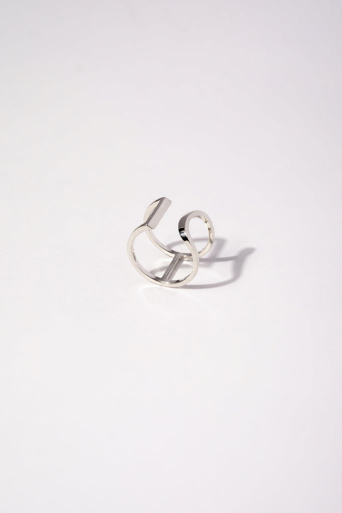 Bague Maison Mouche au design épuré et architectural, en argent 925 100% recyclé et tracé, fabriquée dans des ateliers eco-responsables en Italie. L'AVENTURE est un jeu d’oppositions et de ruptures entre courbes et segments. Les biais accentuent les perspectives, la lumière avive les angles et découpe les espaces.