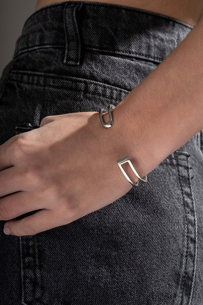 La famille L'AVENTURE se complète de son élégant bracelet jonc. L'AVENTURE est un jeu d’oppositions et de ruptures entre courbes et segments. Les biais accentuent les perspectives, la lumière avive les angles et découpe les espaces. Graphique et épuré, ce bracelet ouvert s'adapte parfaitement à votre poignet, il est léger, ultra-confortable, ne tourne pas et ne vous gênera pas dans vos mouvements.