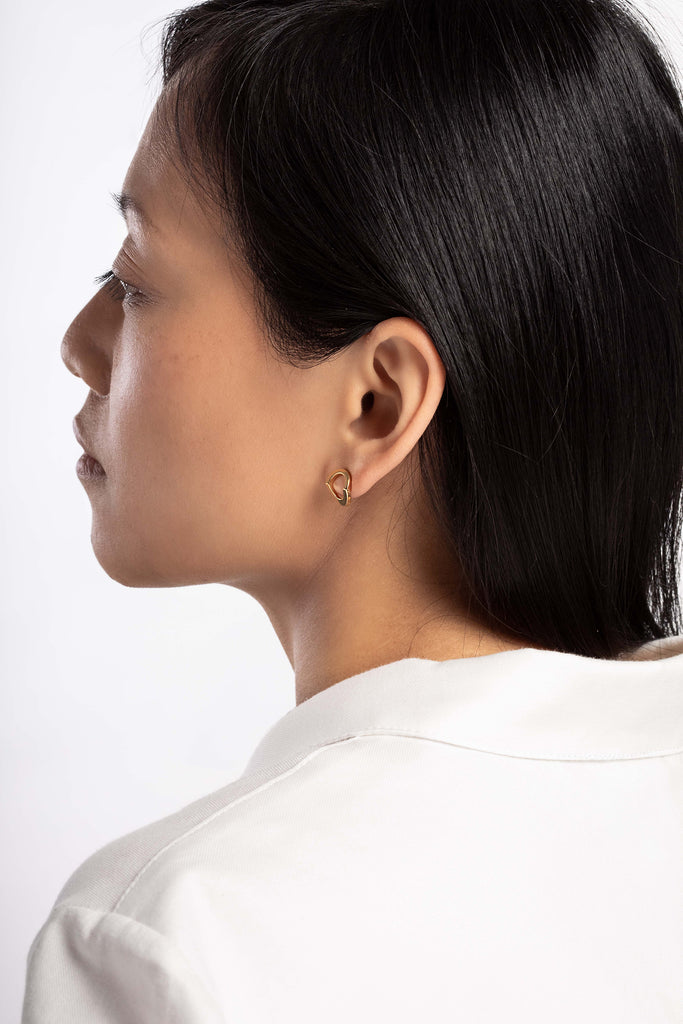 Boucles d'oreille Maison Mouche, cercle ou coeur ? Ces boucles soulignent le dessin de l'oreille et offrent une lecture surprenante de leur forme. Design épuré et minimaliste, en vermeil 100% recyclé et tracé, fabriquées dans des ateliers eco-responsables en Italie. La collection LE SECRET s’inspire des fascinants procédés optiques de l’anamorphose. Selon l'angle de vue, vous y verrez tantôt un cercle parfait, tantôt un croissant, tantôt un coeur dissimulé.